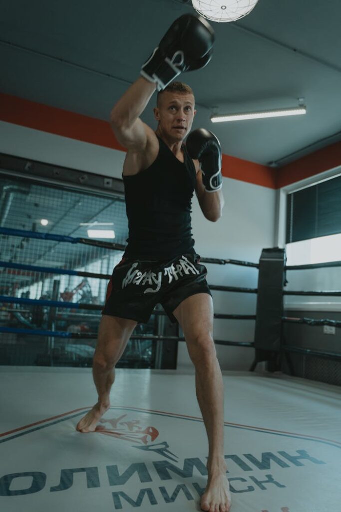 pexels photo 5750956 Caucasian man practicing Muay Thai in a boxing ring indoors.